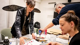 a woman with wings and two other people tinkering with posters