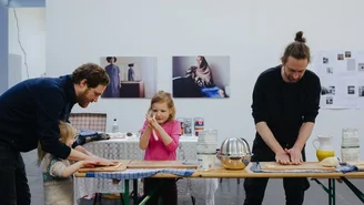 Foto: Pastaworkshop, zwei Erwachsene und zwei Kinder formen Pasta an einem Tisch.