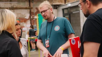 eine Person erzählt an einem Stehtisch mit mehreren Personen von ihrer Kulturorganisation