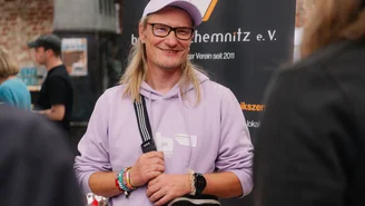 eine Person steht vor einem Aufsteller des Vereins Bandbüro