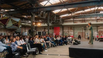 seitlicher Blick auf das Publikum in den voll besetzten Stuhlreihen