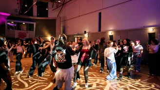 Viele Jugendliche tanzen auf einer Tanzfläche.