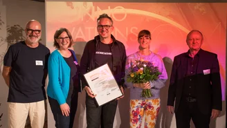 5 Personen mit Urkunde und Blumenstrauß