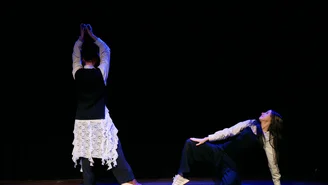 Zwei Tänzer auf einer Bühne während einer Performance.