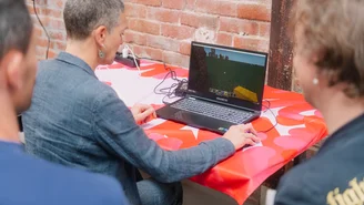 eine Person vor einem Laptop, die anderen schauen ihr über die Schulter