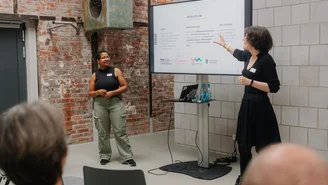 zwei Personen erklären an einem Screen den Workshopablauf