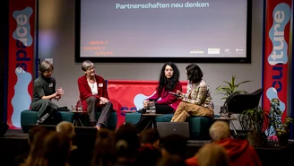 vier Frauen sitzen auf der Bühne während des Panels Partnerschaften neu denken