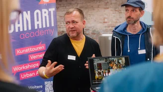 zwei Personen an einem Infostand
