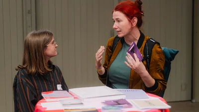 zwei Frauen sprechen an einem Stehtisch miteinander