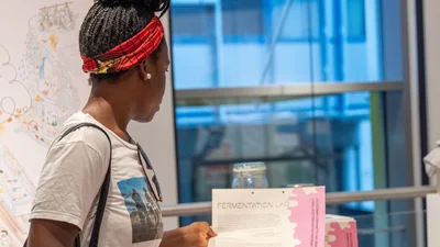 a woman looks at an information leaflet about the exhibition