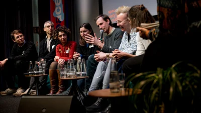 Verschiedene Personen von den Techlab Projekten diskutieren auf der Bühne während der Techlab Konferenz.