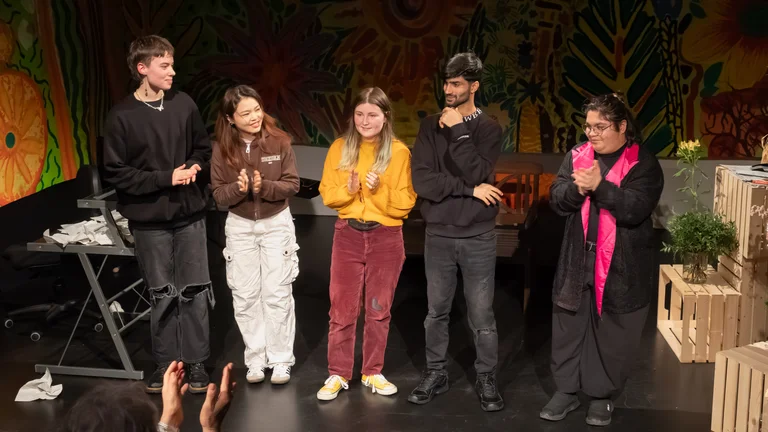 Applause for five young people on stage