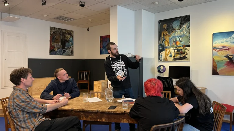 eine Gruppe von jungen Menschen sitzt um einen Tisch