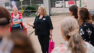 mehrere Personen stehen im Kreis, eine erklärt etwas