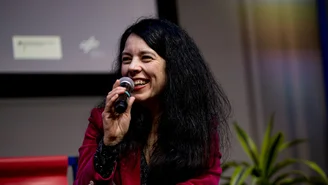Rita Rinaldo lächelt während sie ein Mikro in der Hand hält