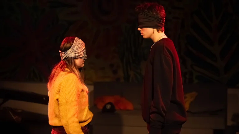 Zwei Frauen stehen sich gegenüber, ihre Augen sind mit Tüchern verbunden. Premiere des Theaterstücks Unsichtbare Wunden.