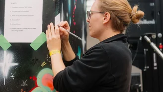 eine Person schreibt eine Frage auf einen Zettel